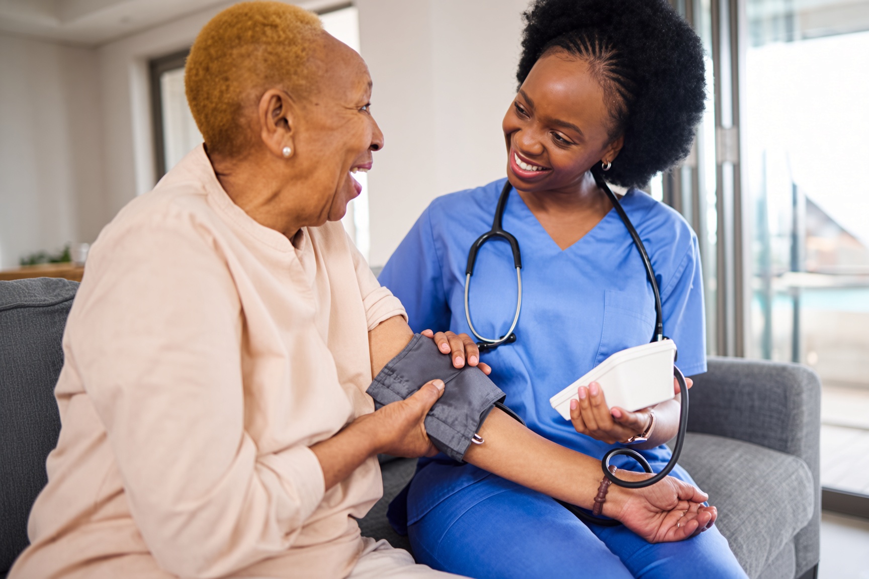 Caregiver taking an elderly client's blood pressure